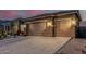 Exterior image of a home's three-car garage at dusk, accented by desert landscaping at 582 W Stirrup Ln, San Tan Valley, AZ 85143
