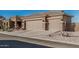 Three-car garage with paneled doors framed by decorative sconces, accented with well-maintained desert landscaping and a terracotta-tiled roof at 582 W Stirrup Ln, San Tan Valley, AZ 85143