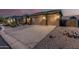 Exterior view of a three car garage featuring desert landscaping and lighting at 582 W Stirrup Ln, San Tan Valley, AZ 85143