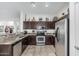 Well appointed kitchen with stainless appliances, tiled floors, decorative tile counters, and warm, dark cabinets at 582 W Stirrup Ln, San Tan Valley, AZ 85143