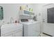 Bright laundry room with white cabinets, sink and washer and dryer at 582 W Stirrup Ln, San Tan Valley, AZ 85143