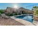 Backyard pool with mature desert landscaping and comfortable lounge chair, perfect for enjoying sunny days and serene evenings at 582 W Stirrup Ln, San Tan Valley, AZ 85143