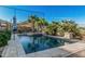 Inviting backyard pool with stone patio, lush greenery, and ample seating, perfect for outdoor entertaining and relaxation at 582 W Stirrup Ln, San Tan Valley, AZ 85143