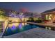 Twilight view of the backyard pool with vibrant, colorful reflected sky and mood lighting, creating a luxurious ambiance at 582 W Stirrup Ln, San Tan Valley, AZ 85143