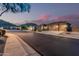 Street view of well-maintained homes with three-car garages, complemented by desert landscaping at 582 W Stirrup Ln, San Tan Valley, AZ 85143