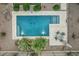 Aerial view of a sparkling swimming pool with travertine surround, patio table, and desert landscaping at 582 W Stirrup Ln, San Tan Valley, AZ 85143