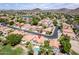 Scenic aerial shot of a neighborhood featuring houses with tiled roofs, a serene lake, and green landscapes, creating a peaceful setting at 5953 W Aurora Dr, Glendale, AZ 85308