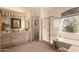 Bright bathroom featuring a double vanity, bathtub, and a shower with glass enclosure at 5953 W Aurora Dr, Glendale, AZ 85308