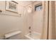 Bathroom features tub with shower, neutral tile, and a shower curtain at 5953 W Aurora Dr, Glendale, AZ 85308