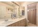 Bathroom with double sinks, decorative mirrors, and a shower with a patterned curtain at 5953 W Aurora Dr, Glendale, AZ 85308