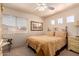 Cozy bedroom features a comfortable bed, natural light, and a ceiling fan at 5953 W Aurora Dr, Glendale, AZ 85308
