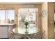Bright dining area with a glass table, white chairs, and scenic backyard view at 5953 W Aurora Dr, Glendale, AZ 85308