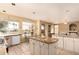 Sunlit kitchen with an island, tiled floors, granite countertops, and a cozy dining space at 5953 W Aurora Dr, Glendale, AZ 85308