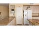 Kitchen featuring granite countertops, white cabinets, and a refrigerator at 5953 W Aurora Dr, Glendale, AZ 85308