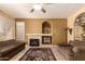 Living room with tan colored walls and neutral colored furnishings, tile flooring, fireplace, and ceiling fan at 5953 W Aurora Dr, Glendale, AZ 85308