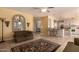 Open-concept living room with tile floors and a partial view of the kitchen and breakfast bar at 5953 W Aurora Dr, Glendale, AZ 85308