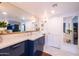 Bathroom with a large mirror, vanity with white countertop, and modern lighting with decorative shelving at 6314 N 14Th St, Phoenix, AZ 85014