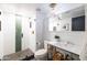 The bathroom features a sleek glass shower, modern fixtures, and a unique green wall tile design at 6314 N 14Th St, Phoenix, AZ 85014