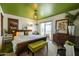 Bright primary bedroom features a rattan bed frame, unique green ceiling, and seamless access to a private patio at 6314 N 14Th St, Phoenix, AZ 85014