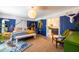 Stylish bedroom with blue accent walls, eclectic decor, and an attached, well-lit bathroom at 6314 N 14Th St, Phoenix, AZ 85014