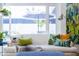 Bright and airy living room features a white sofa, tropical-patterned pillows, and a picturesque window view at 6314 N 14Th St, Phoenix, AZ 85014
