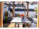 Cozy patio with a large table, overhead shade cover, modern seating, and privacy fence and foliage at 6314 N 14Th St, Phoenix, AZ 85014
