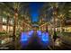 Beautiful community view of palm trees, fountains, and walkways at night at 6351 E Waltann Ln, Scottsdale, AZ 85254