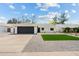 Charming single-story home with manicured lawn, dark garage door, and gravel landscaping at 6351 E Waltann Ln, Scottsdale, AZ 85254