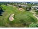An aerial view of a golf course featuring a meticulously maintained green, sand traps, and scenic landscapes at 6351 E Waltann Ln, Scottsdale, AZ 85254