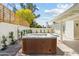 Relaxing backyard hot tub area featuring a lattice fence, desert landscaping, and partially covered patio with swimming pool at 6351 E Waltann Ln, Scottsdale, AZ 85254