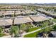 Expansive aerial shot showcasing a community with well-maintained homes, green lawns, and tidy landscaping under a sunny sky at 650 E Myrtle Pass, Queen Creek, AZ 85140
