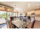 Open dining space with glass table, six chairs, and access to outdoor patio and an open layout to the kitchen at 650 E Myrtle Pass, Queen Creek, AZ 85140