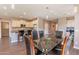 Dining area with glass table, seating for six, and an open floor plan to the kitchen and living area at 650 E Myrtle Pass, Queen Creek, AZ 85140