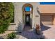 The charming arched entry leads to the front door, framed by desert landscaping and an inviting facade at 650 E Myrtle Pass, Queen Creek, AZ 85140