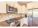 A stainless steel range and microwave sit above a stone countertop in this well-lit kitchen at 650 E Myrtle Pass, Queen Creek, AZ 85140