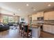 Spacious kitchen with an island bar, stainless appliances, tile backsplash, and an open view to the living room at 650 E Myrtle Pass, Queen Creek, AZ 85140