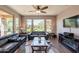 Comfortable living room showcasing large windows with backyard views, dark leather couches, and a ceiling fan at 650 E Myrtle Pass, Queen Creek, AZ 85140