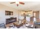Open-concept living room with a fireplace, ceiling fan, and views into the kitchen with stainless steel appliances at 650 E Myrtle Pass, Queen Creek, AZ 85140