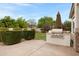 Backyard patio with a built in grill and a lush green lawn with neatly trimmed landscaping at 6694 S Banning St, Gilbert, AZ 85298