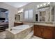 This bathroom features double sinks, a soaking tub, tile floors, and warm neutral paint at 6694 S Banning St, Gilbert, AZ 85298