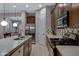 Chef's kitchen featuring dark cabinets, quartz counters, stainless appliances and a large island at 6694 S Banning St, Gilbert, AZ 85298