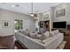 Bright living room featuring a large sofa, hardwood floors, and access to the backyard at 6694 S Banning St, Gilbert, AZ 85298