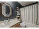Dark-walled bathroom featuring an ornate mirror, vanity, and shower with a tub at 720 W Gail Ct, Gilbert, AZ 85233
