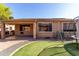 A spacious backyard featuring artificial grass, a trampoline, and a covered patio at 7424 W Pioneer St, Phoenix, AZ 85043