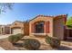 Tan stucco home featuring low-maintenance landscaping and charming red shutters on the window at 7424 W Pioneer St, Phoenix, AZ 85043