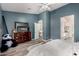 Serene main bedroom with blue accent wall, wood-look flooring, and open access to the bathroom at 7424 W Pioneer St, Phoenix, AZ 85043