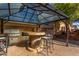 An outdoor kitchen with a grill, counter seating, and a covered gazebo at 7424 W Pioneer St, Phoenix, AZ 85043