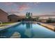 This backyard pool with serene views offers a tranquil escape, framed by lush landscaping and a beautiful sky at 766 E Taylor Trl, San Tan Valley, AZ 85143