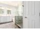 Bright bathroom featuring a double sink vanity, frameless glass shower and a soaking tub at 81 E Rock Wren Dr, San Tan Valley, AZ 85143
