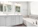 A bathroom featuring a double vanity, a soaking tub, and a marble accent wall at 81 E Rock Wren Dr, San Tan Valley, AZ 85143